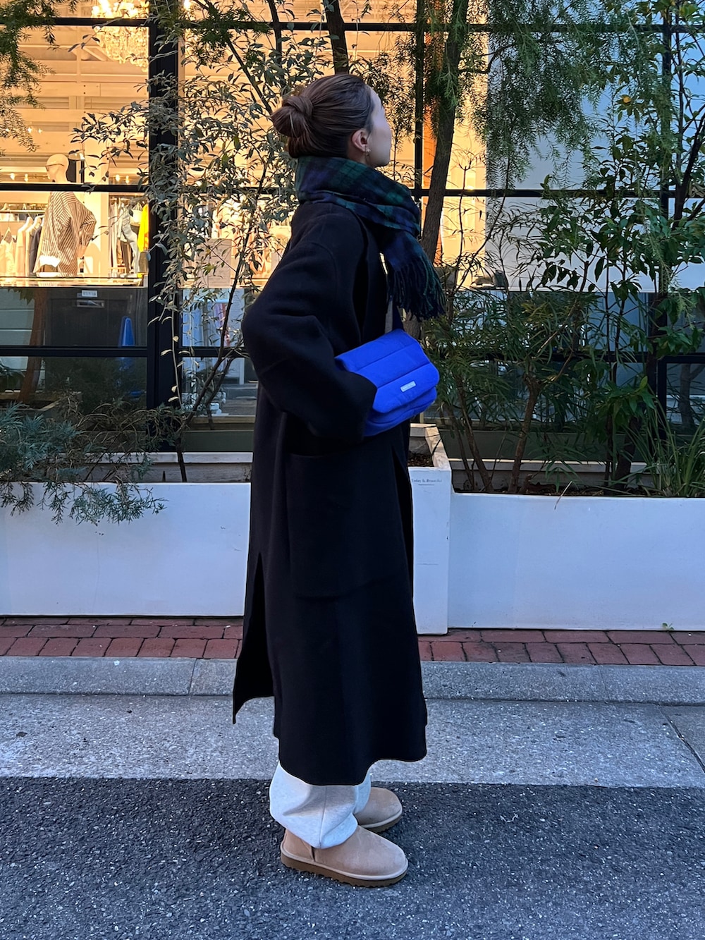 グレー系のスウェット、ブラック系のチェスターコート、グレー系のスウェットパンツを着用したレディースの冬コーディネートの3枚目の写真