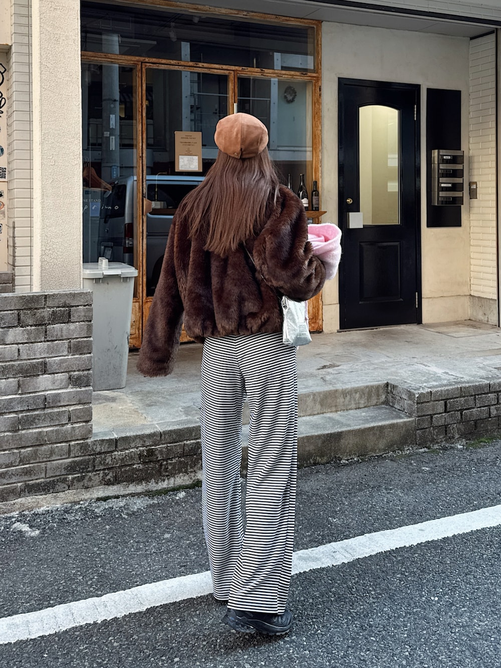 ブラウン系のジャケット/アウター、ブラック系のスウェットパンツ、ブラック系のスニーカーを着用したレディースの冬コーディネートの3枚目の写真