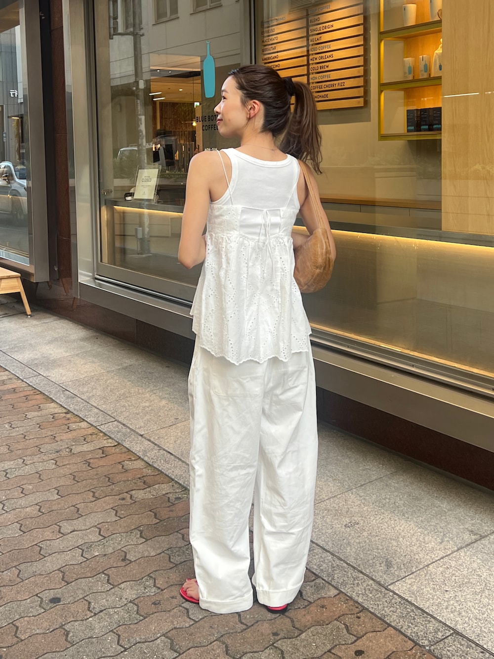 ホワイト系のキャミソール、ホワイト系のタンクトップ、ホワイト系のチノパンツを着用したレディースの夏コーディネートの3枚目の写真