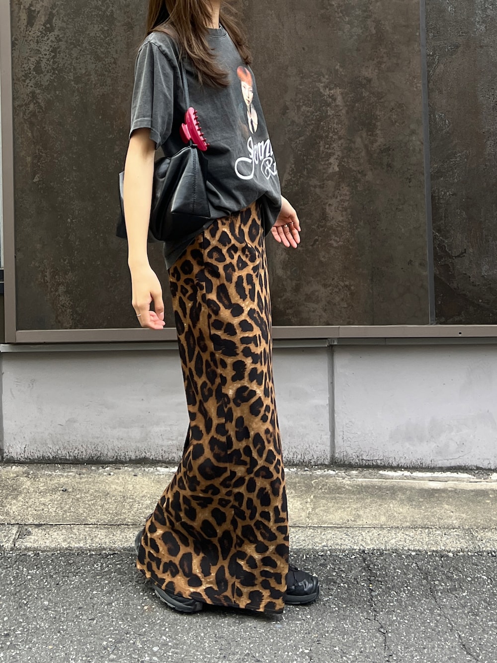 ブラック系のスニーカー、ブラック系のTシャツ/カットソー、ブラック系のショルダーバッグを着用したレディースの夏コーディネートの3枚目の写真