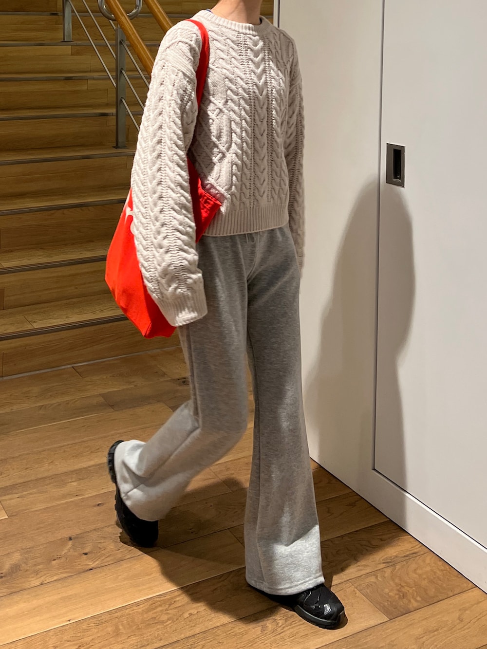 ベージュ系のニット/セーター、グレー系のスウェットパンツ、ブラック系のスニーカーを着用したレディースの冬コーディネートの3枚目の写真
