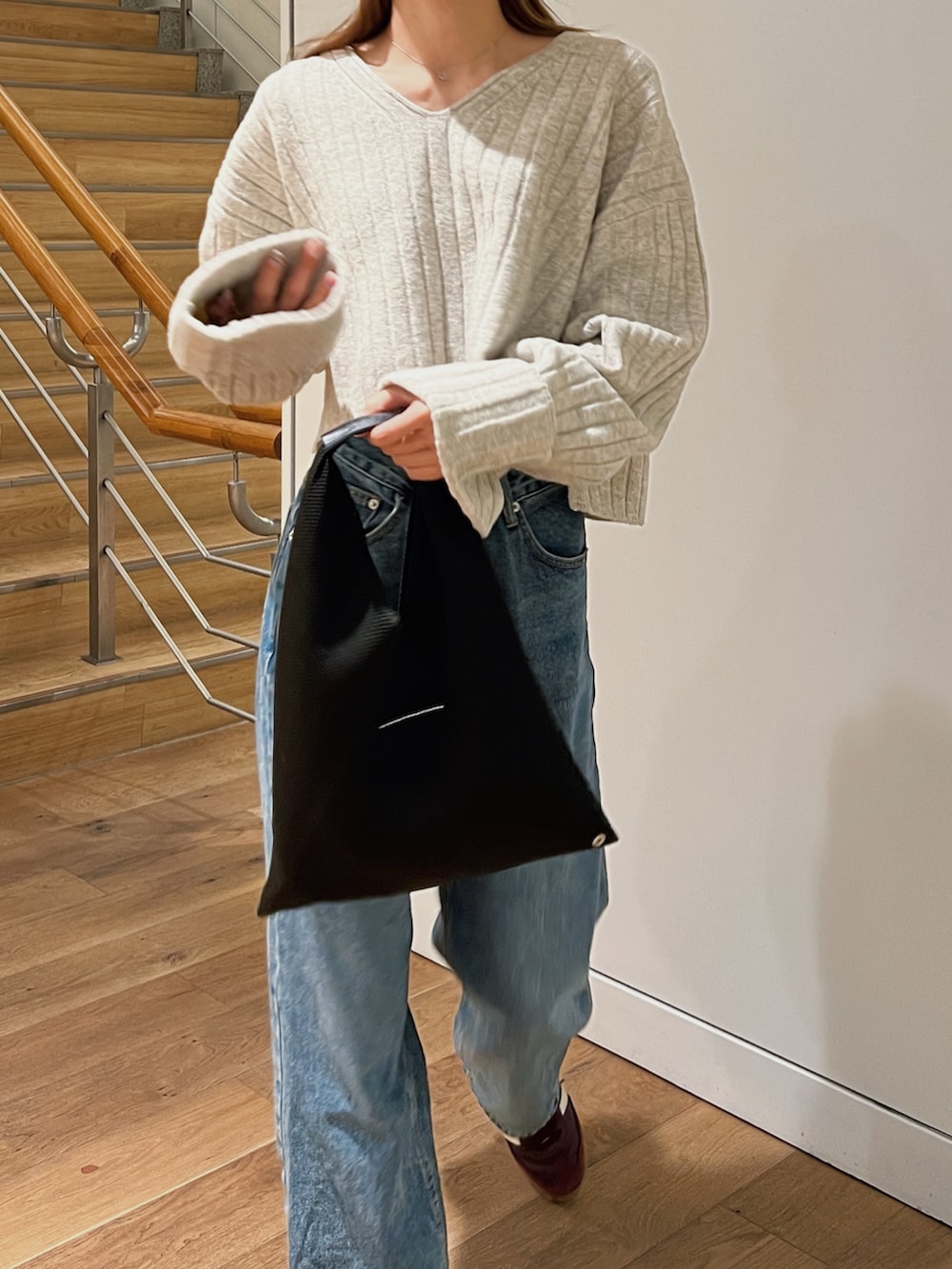 ホワイト系のニット/セーター、ブルー系のデニムパンツ、レッド系のスニーカーを着用したレディースの秋コーディネートの3枚目の写真