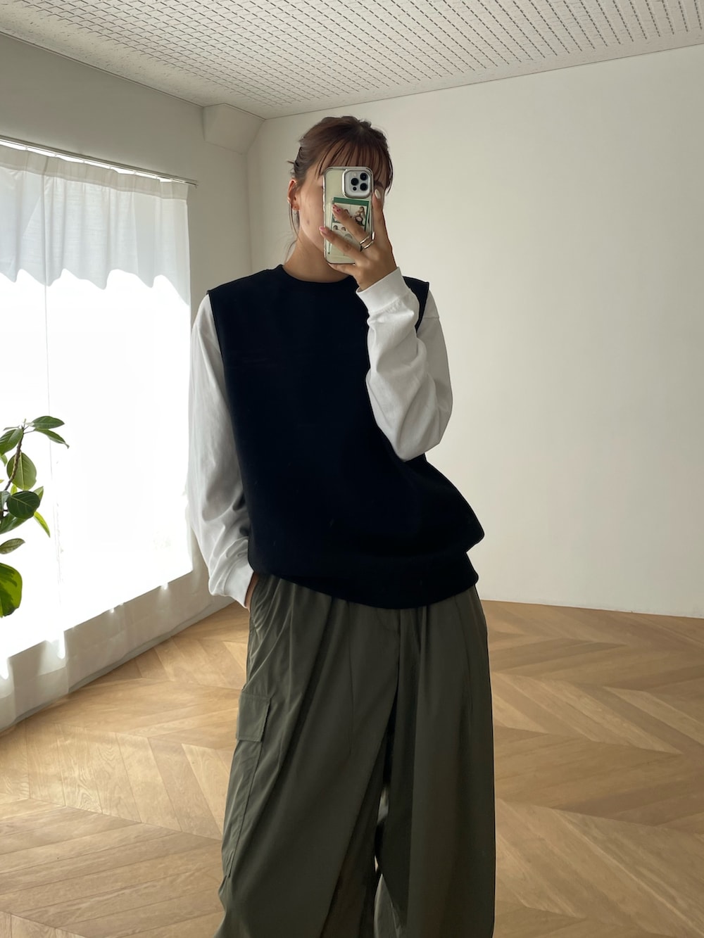 グリーン系のカーゴパンツ、ブラック系のベストを着用したレディースの夏コーディネートの3枚目の写真