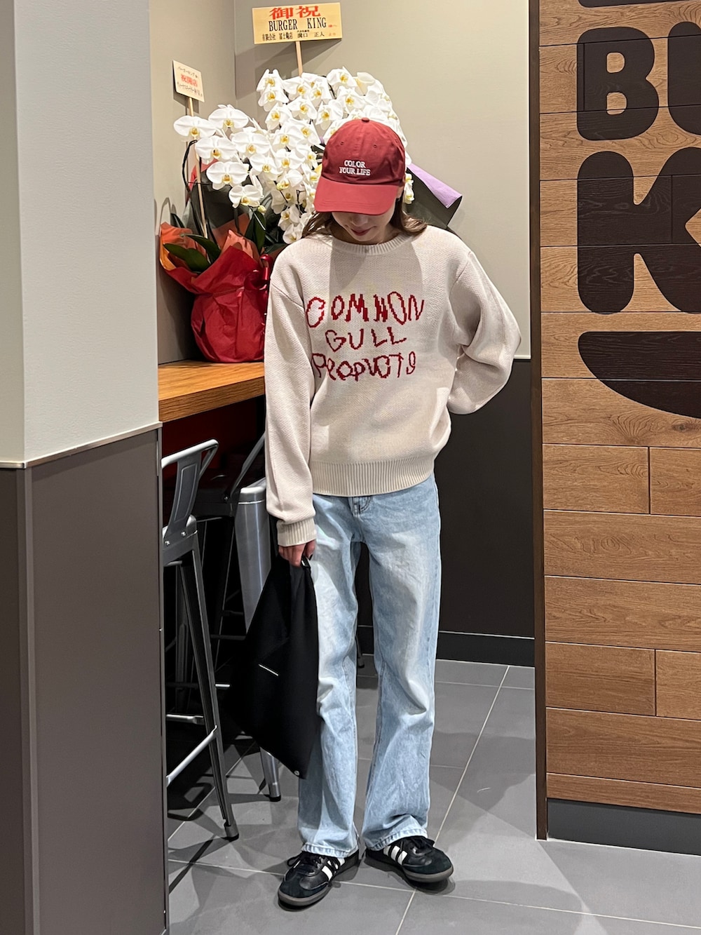 ベージュ系のニット/セーター、ブルー系のデニムパンツ、ブラック系のスニーカーを着用したレディースの冬コーディネートの2枚目の写真