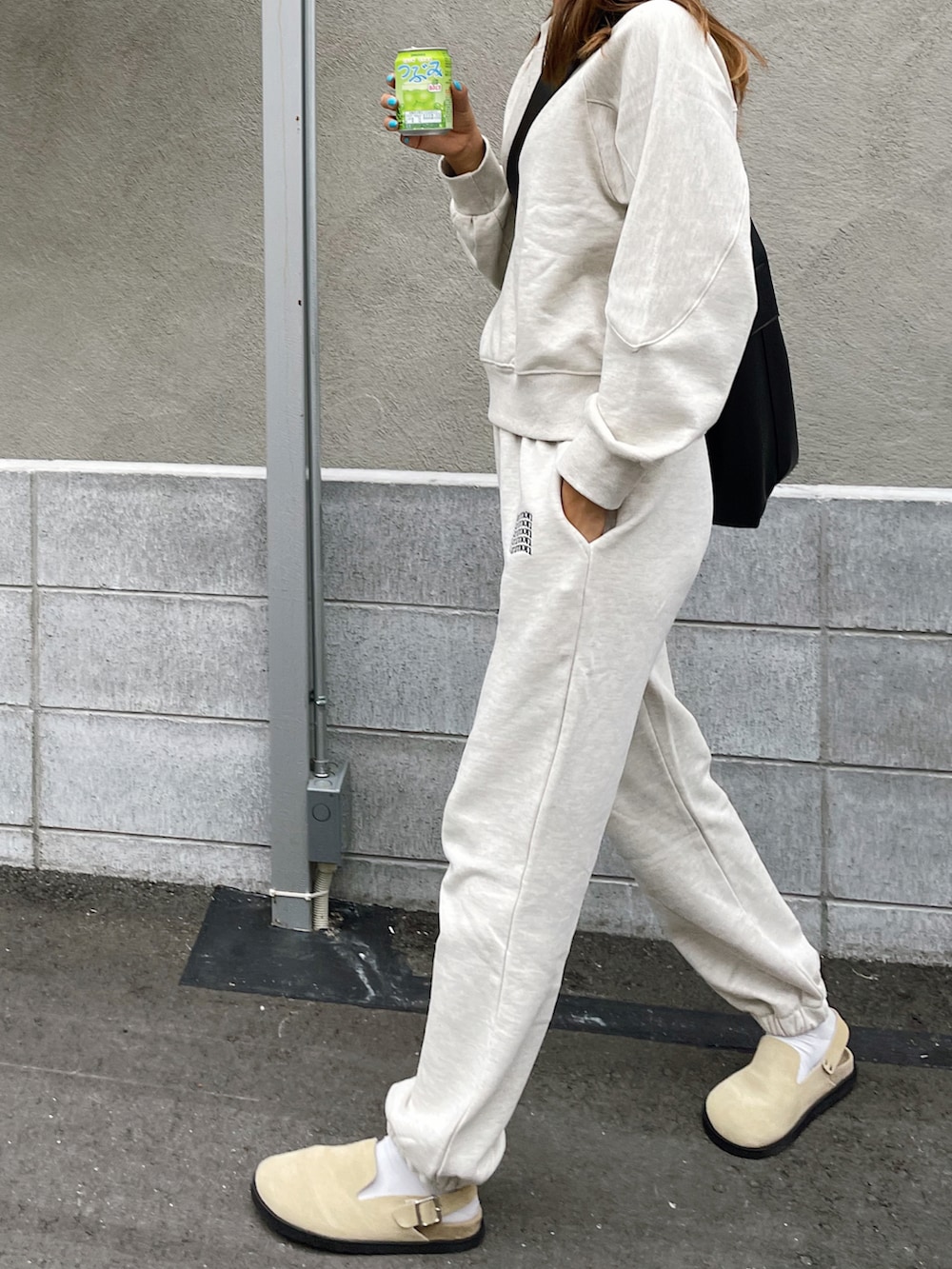 ベージュ系のスウェット、ベージュ系のスウェットパンツ、ベージュ系のスリッポンを着用したレディースの秋コーディネートの2枚目の写真