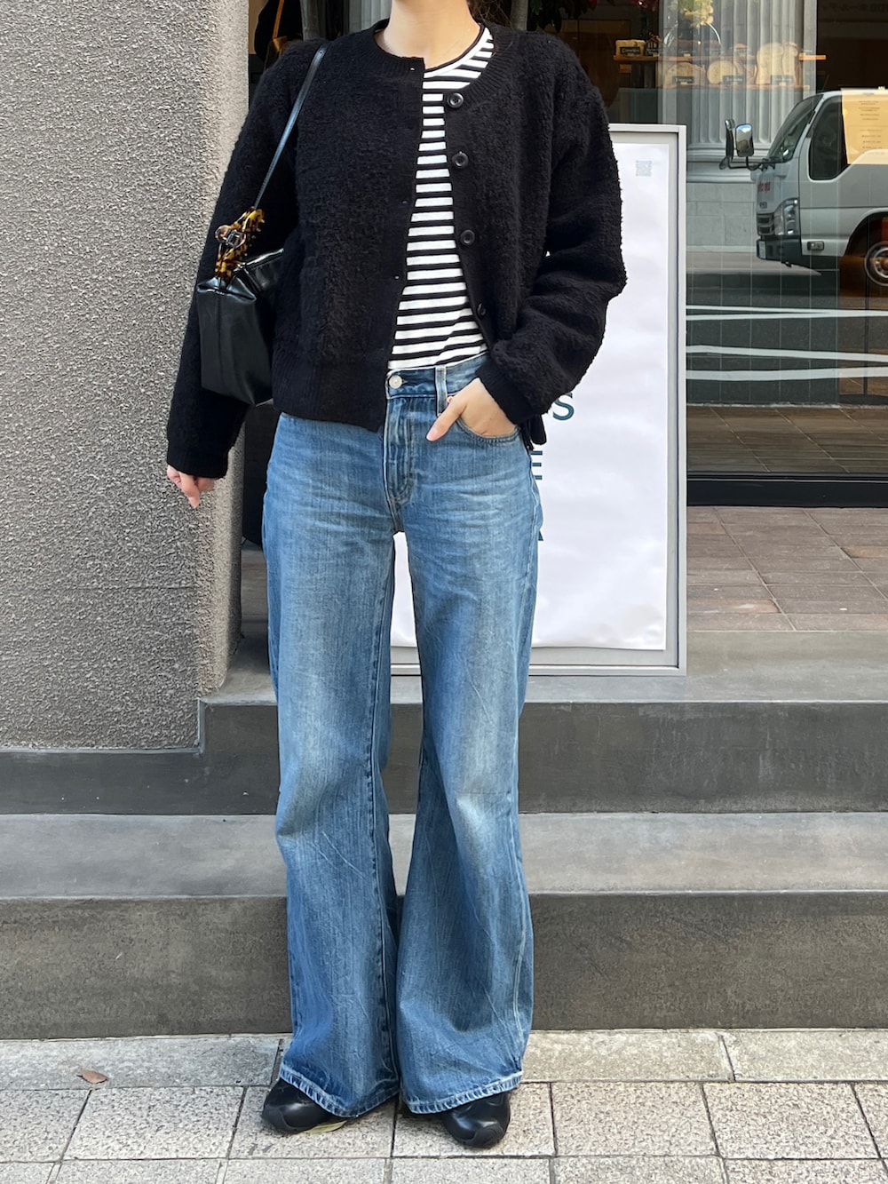 ブラック系のノーカラージャケット、グレー系のTシャツ/カットソー、ブラック系のショルダーバッグを着用したレディースの冬コーディネートの3枚目の写真