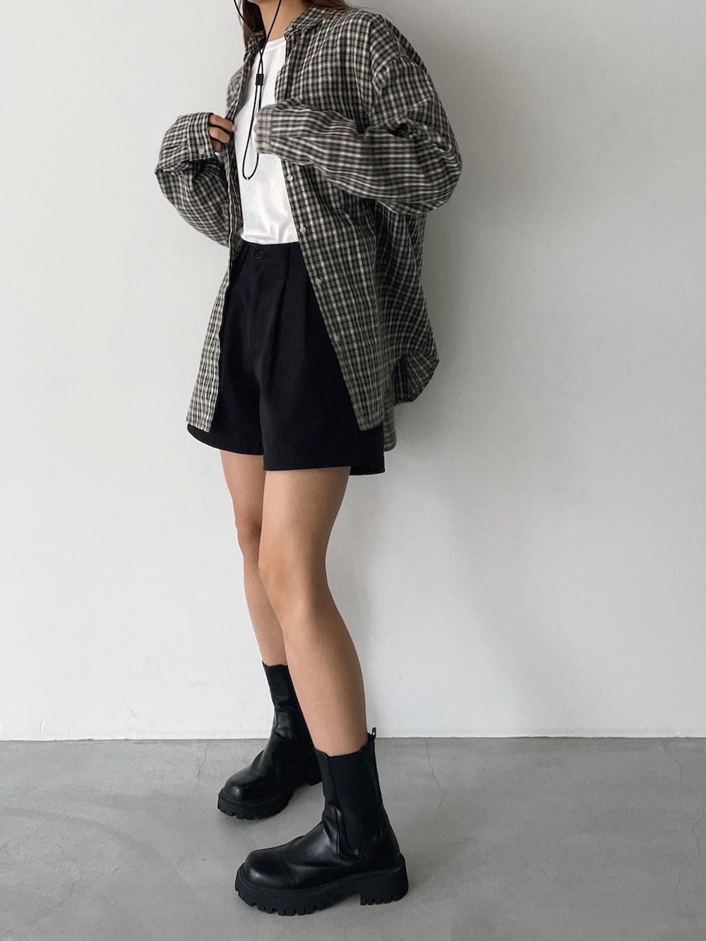 ブラック系のその他パンツ、ホワイト系のTシャツ/カットソー、ブラック系のブーツを着用したレディースの秋コーディネートの3枚目の写真