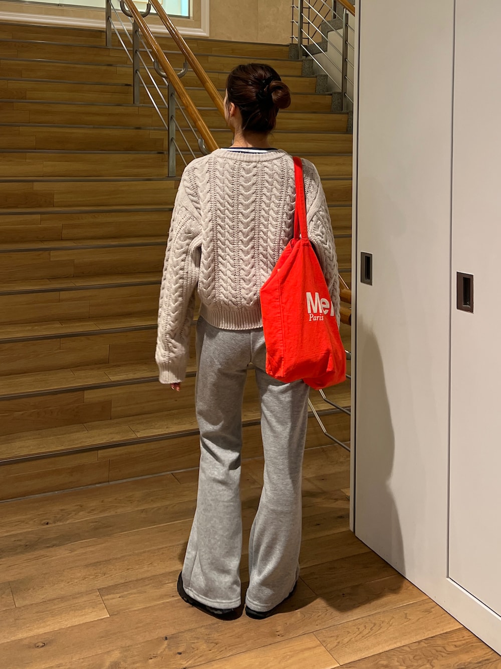 ベージュ系のニット/セーター、グレー系のスウェットパンツ、ブラック系のスニーカーを着用したレディースの冬コーディネートの2枚目の写真