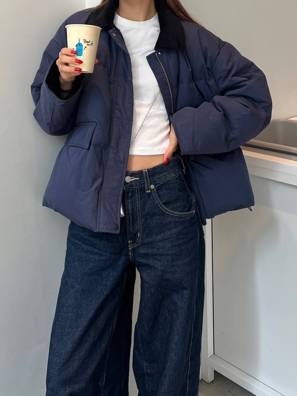 ホワイト系のTシャツ/カットソー、ブルー系のダウンジャケット/コート、シルバー系のバッグを着用したレディースの秋コーディネートの2枚目の写真