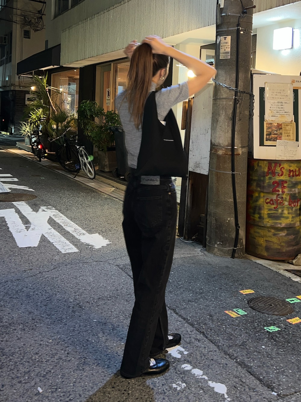 グレー系のTシャツ/カットソー、ブラック系のデニムパンツ、ブラック系のショルダーバッグを着用したレディースの秋コーディネートの3枚目の写真