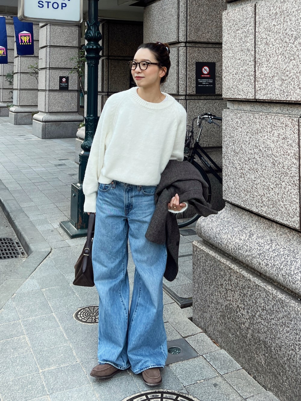 ホワイト系のニット/セーター、ブラウン系のショルダーバッグ、ブラウン系のモカシン/デッキシューズを着用したレディースの冬コーディネートの2枚目の写真