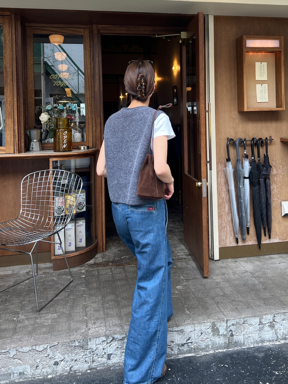 グレー系のベスト、ブルー系のチノパンツ、ブラウン系のモカシン/デッキシューズを着用したレディースの春コーディネートの3枚目の写真