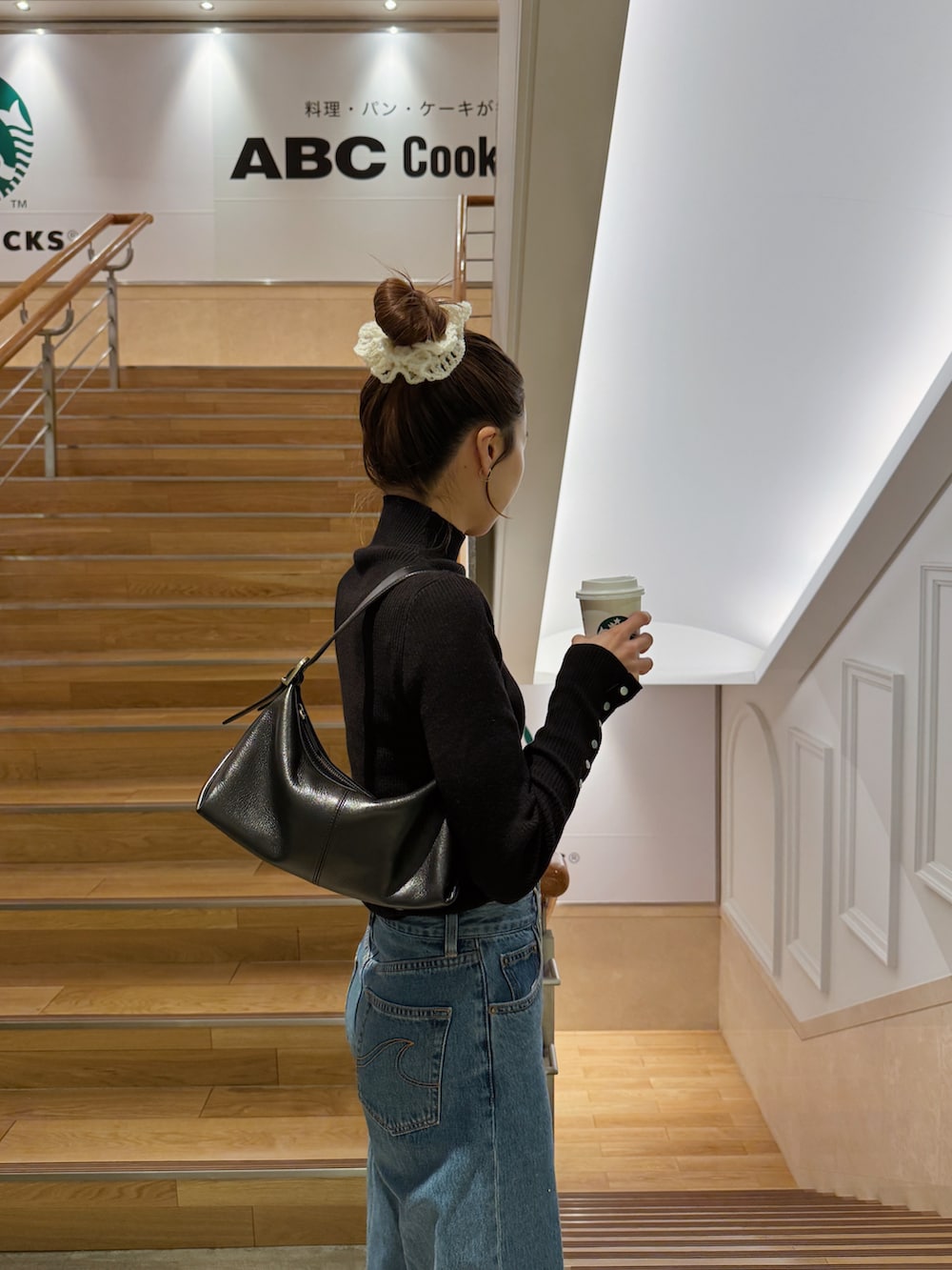 ブラック系のニット/セーター、ブルー系のデニムパンツ、ブラック系のスニーカーを着用したレディースの冬コーディネートの2枚目の写真