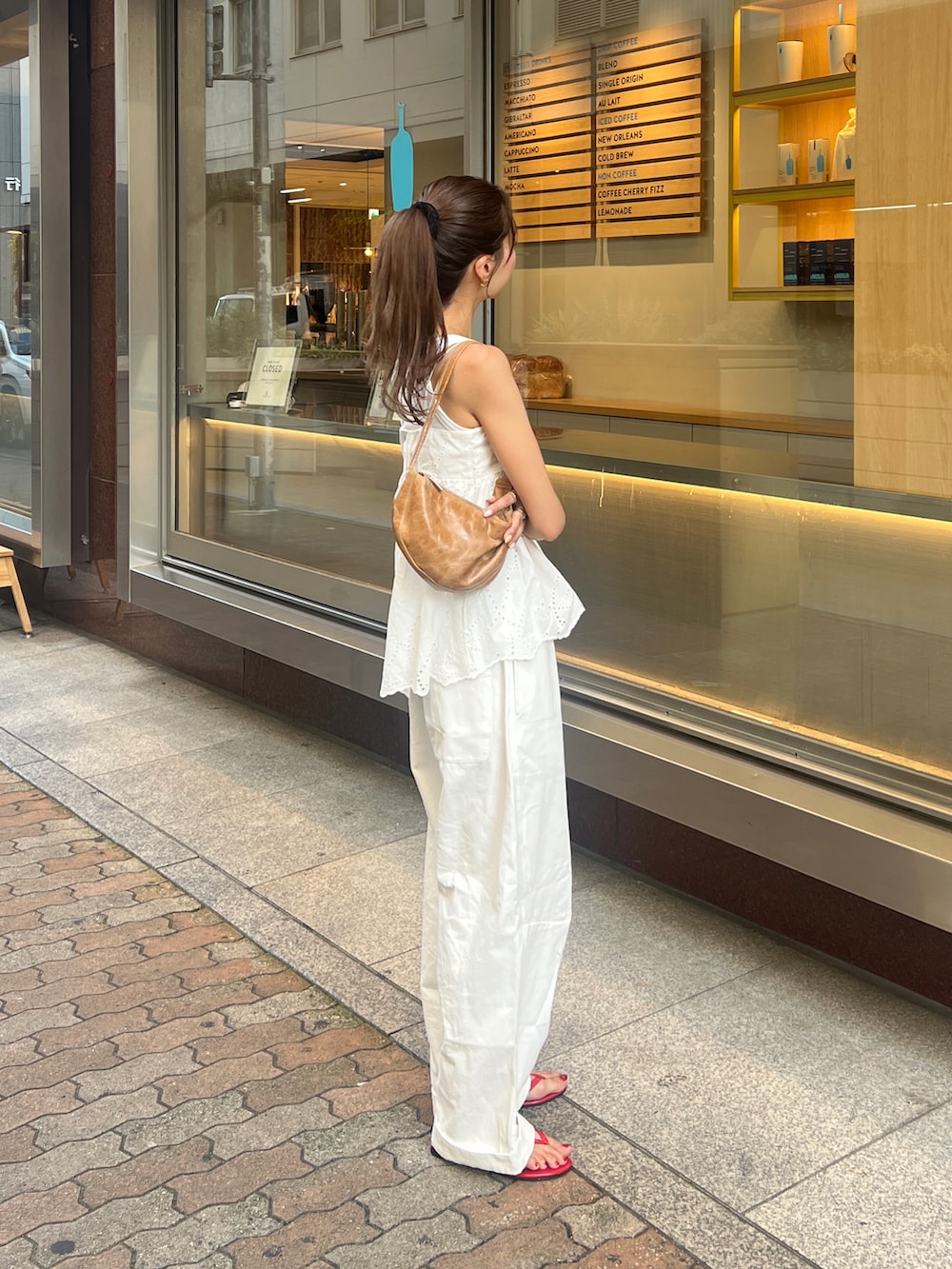 ホワイト系のキャミソール、ホワイト系のタンクトップ、ホワイト系のチノパンツを着用したレディースの夏コーディネートの2枚目の写真