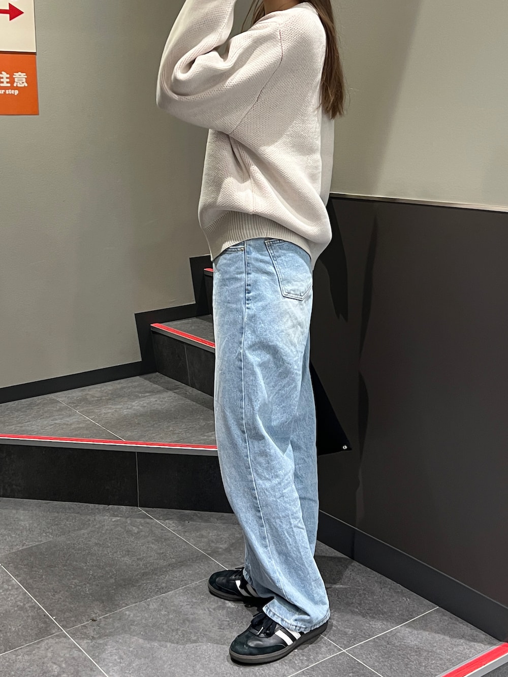 ベージュ系のニット/セーター、ブルー系のデニムパンツ、ブラック系のスニーカーを着用したレディースの冬コーディネートの3枚目の写真