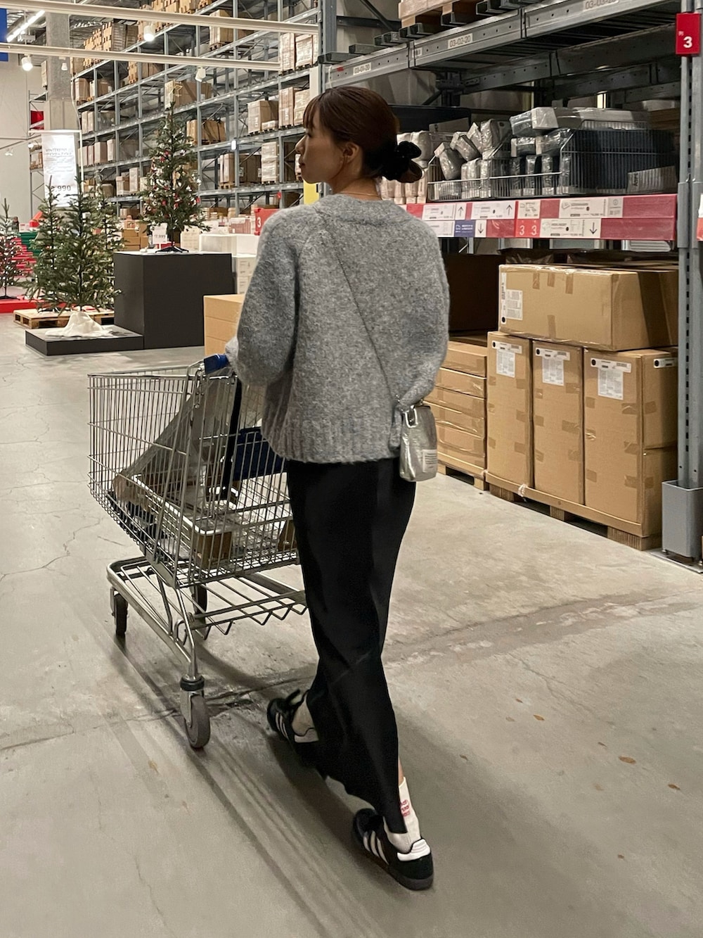 ホワイト系のTシャツ/カットソー、グレー系のカーディガン/ボレロ、ブラック系のスカートを着用したレディースの冬コーディネートの2枚目の写真