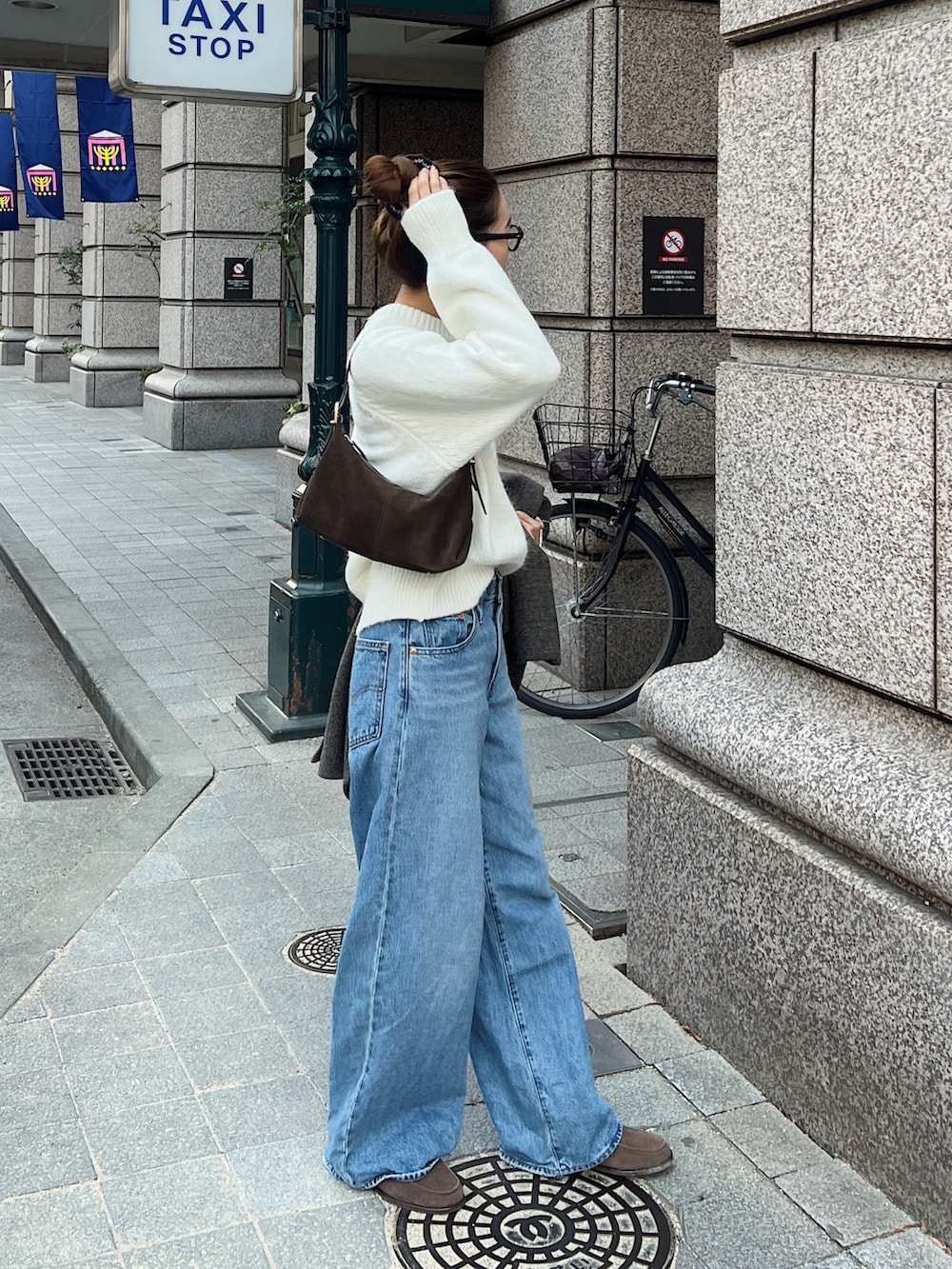 ホワイト系のニット/セーター、ブラウン系のショルダーバッグ、ブラウン系のモカシン/デッキシューズを着用したレディースの冬コーディネートの3枚目の写真