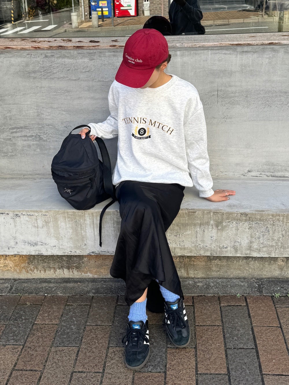 グレー系のスウェット、ブラック系のバックパック/リュック、ブラック系のスカートを着用したレディースの秋コーディネートの3枚目の写真