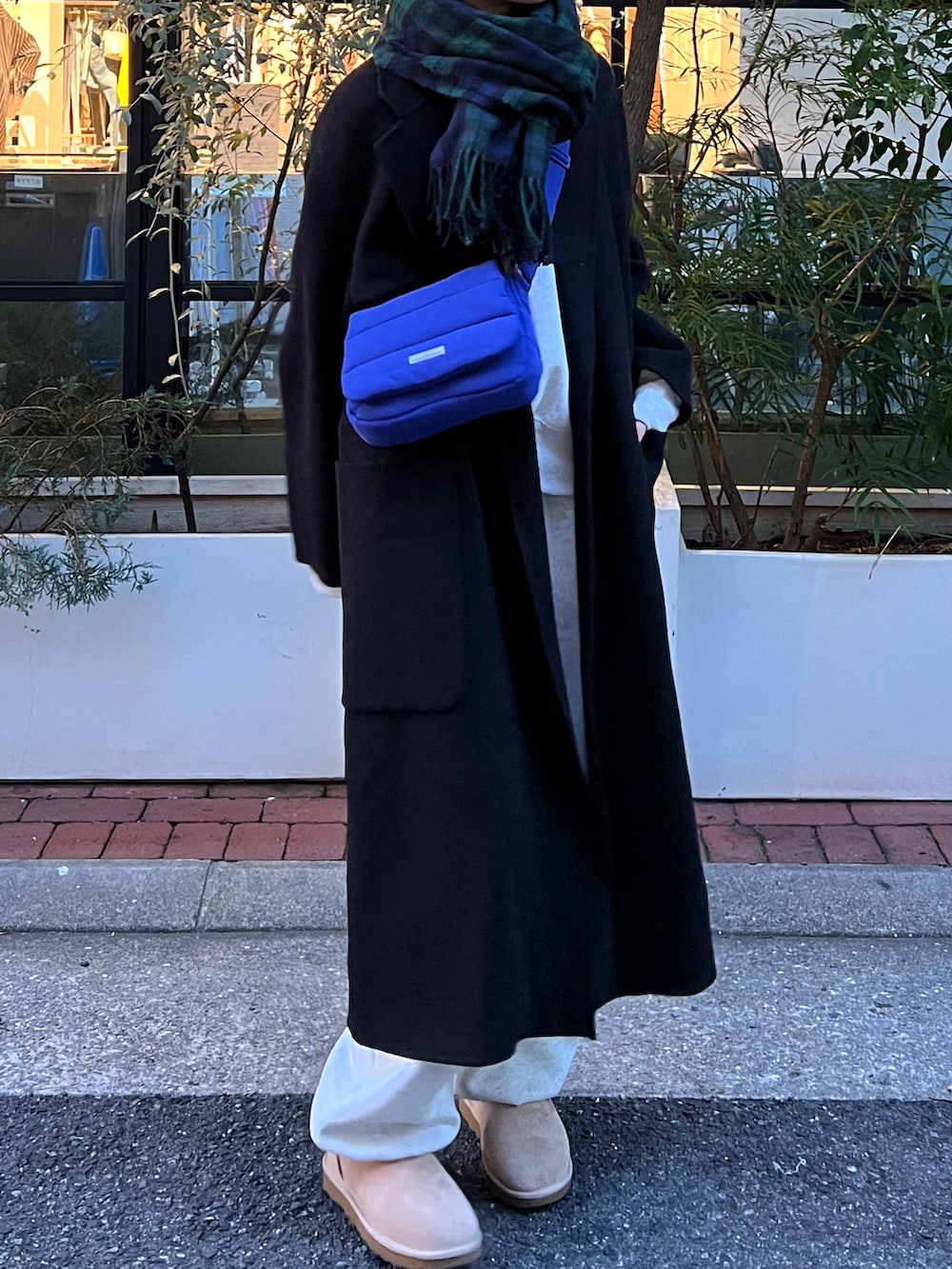 グレー系のスウェット、ブラック系のチェスターコート、グレー系のスウェットパンツを着用したレディースの冬コーディネートの4枚目の写真