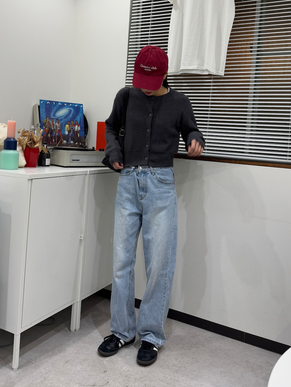 ベージュ系のブルゾン、ブルー系のデニムパンツ、ブラック系のスニーカーを着用したレディースの冬コーディネートの4枚目の写真