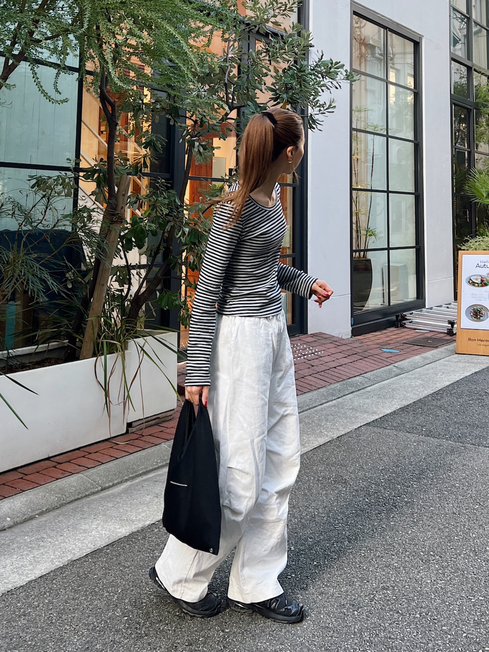 グレー系のTシャツ/カットソー、ホワイト系のチノパンツ、ブラック系のスニーカーを着用したレディースの秋コーディネートの3枚目の写真