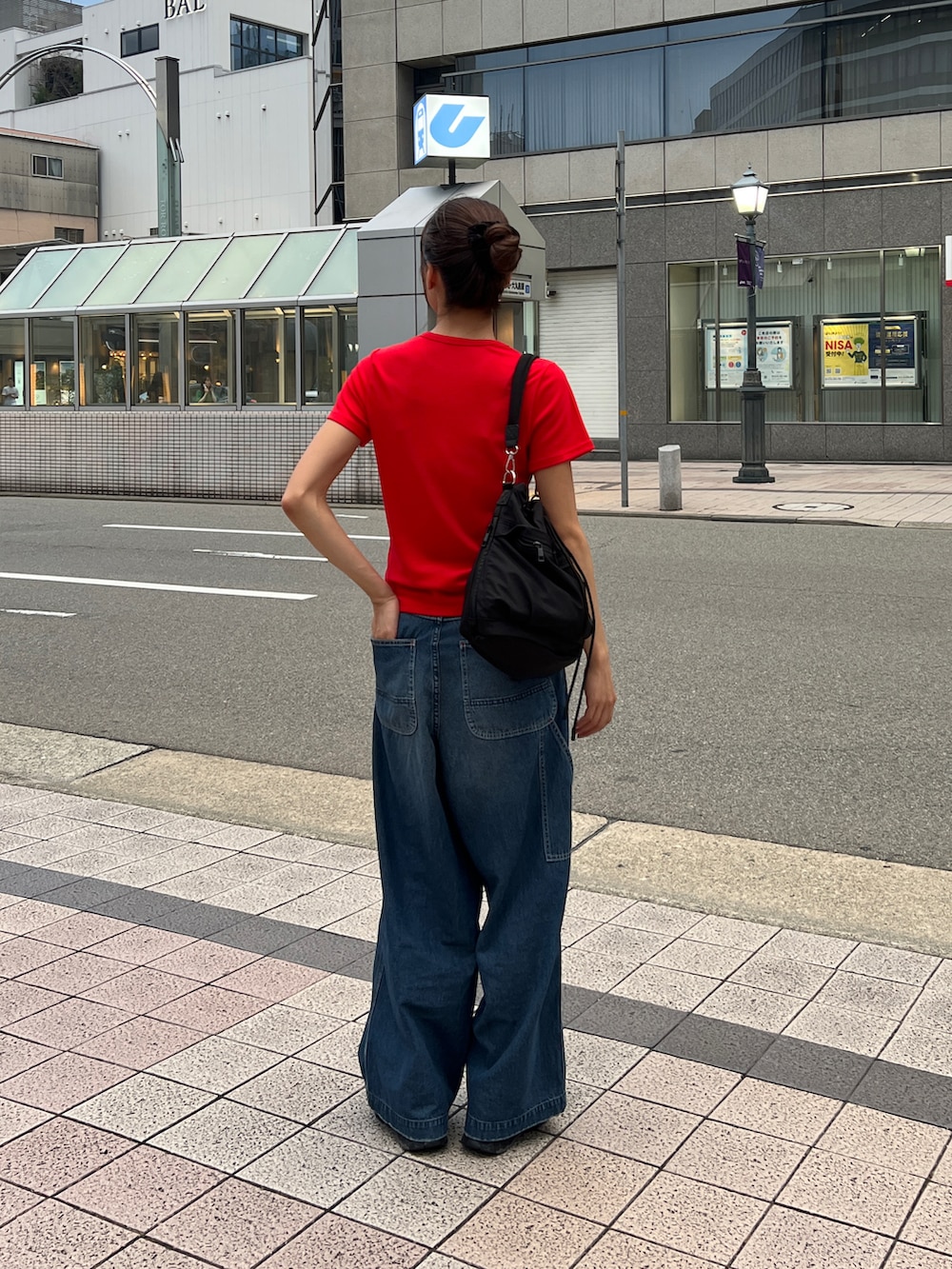 レッド系のTシャツ/カットソー、ブルー系のデニムパンツ、ブラック系のショルダーバッグを着用したレディースの夏コーディネートの3枚目の写真