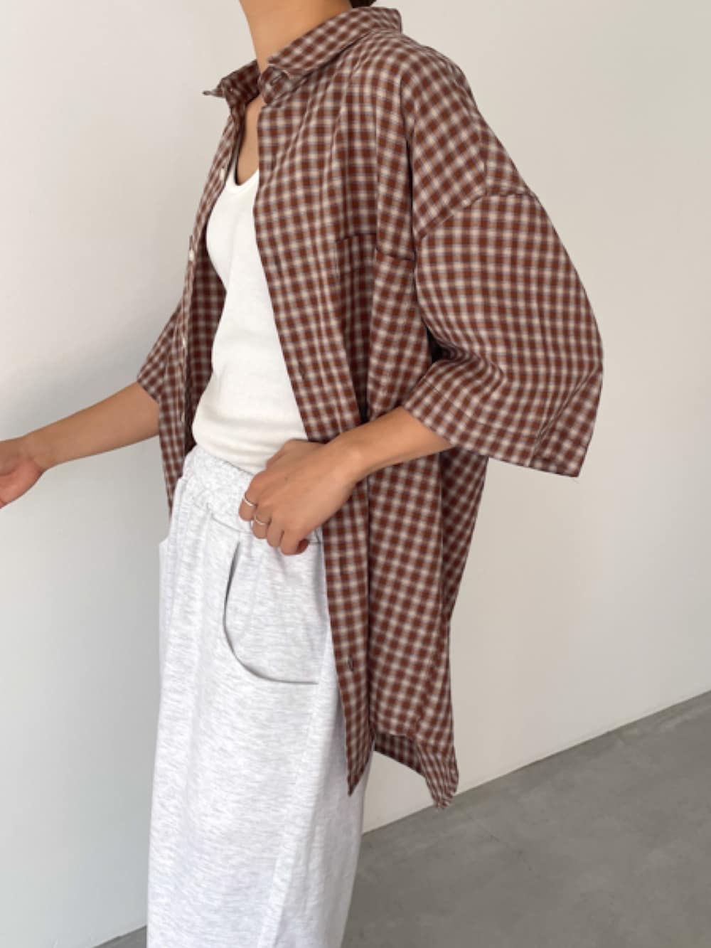 グレー系のスウェットパンツ、ベージュ系のシャツ/ブラウス、ホワイト系のタンクトップを着用したレディースの春コーディネートの3枚目の写真