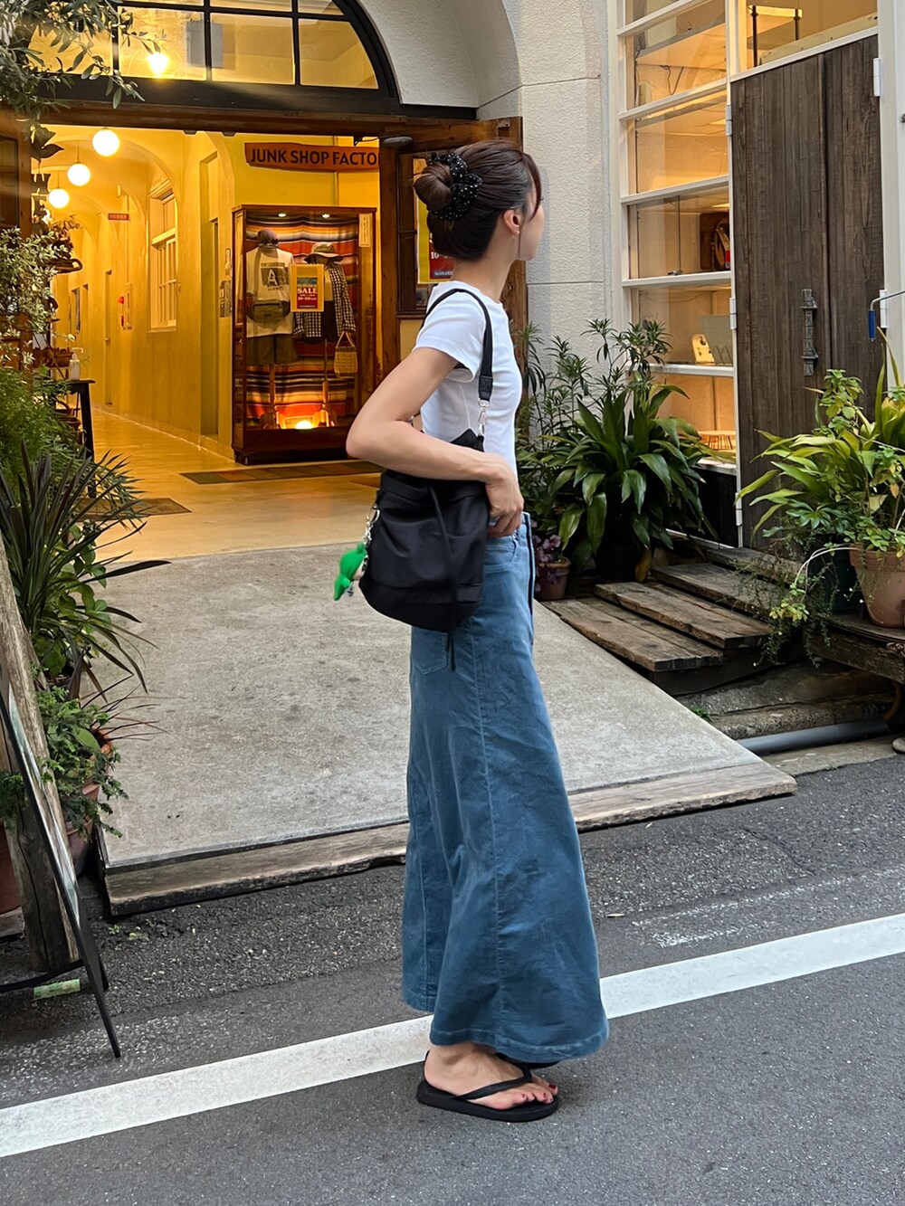 ブラック系のショルダーバッグ、ブラック系のサンダル、ブルー系のスカートを着用したレディースの夏コーディネートの3枚目の写真