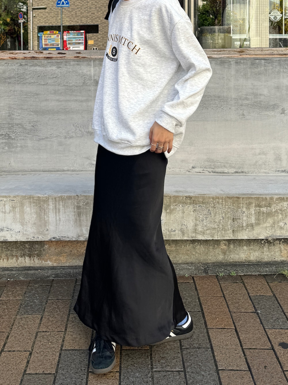 グレー系のスウェット、ブラック系のバックパック/リュック、ブラック系のスカートを着用したレディースの秋コーディネートの4枚目の写真