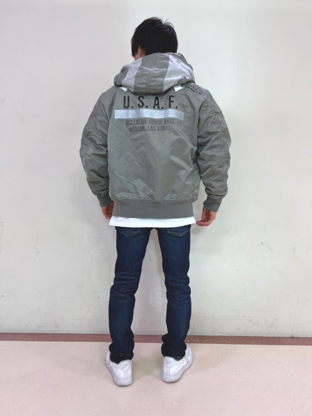 グレー系のMA-1、ホワイト系のTシャツ/カットソー、ブラウン系のベルトを着用したメンズの冬コーディネートの2枚目の写真