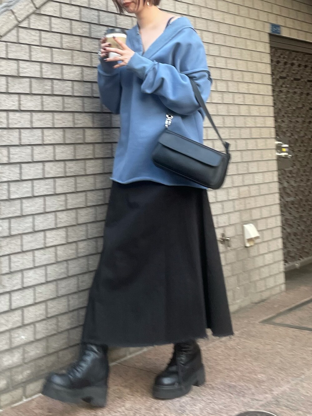 ブルー系のTシャツ/カットソー、ブラック系のハンドバッグ、ブラック系のスカートを着用したレディースの秋コーディネートの3枚目の写真