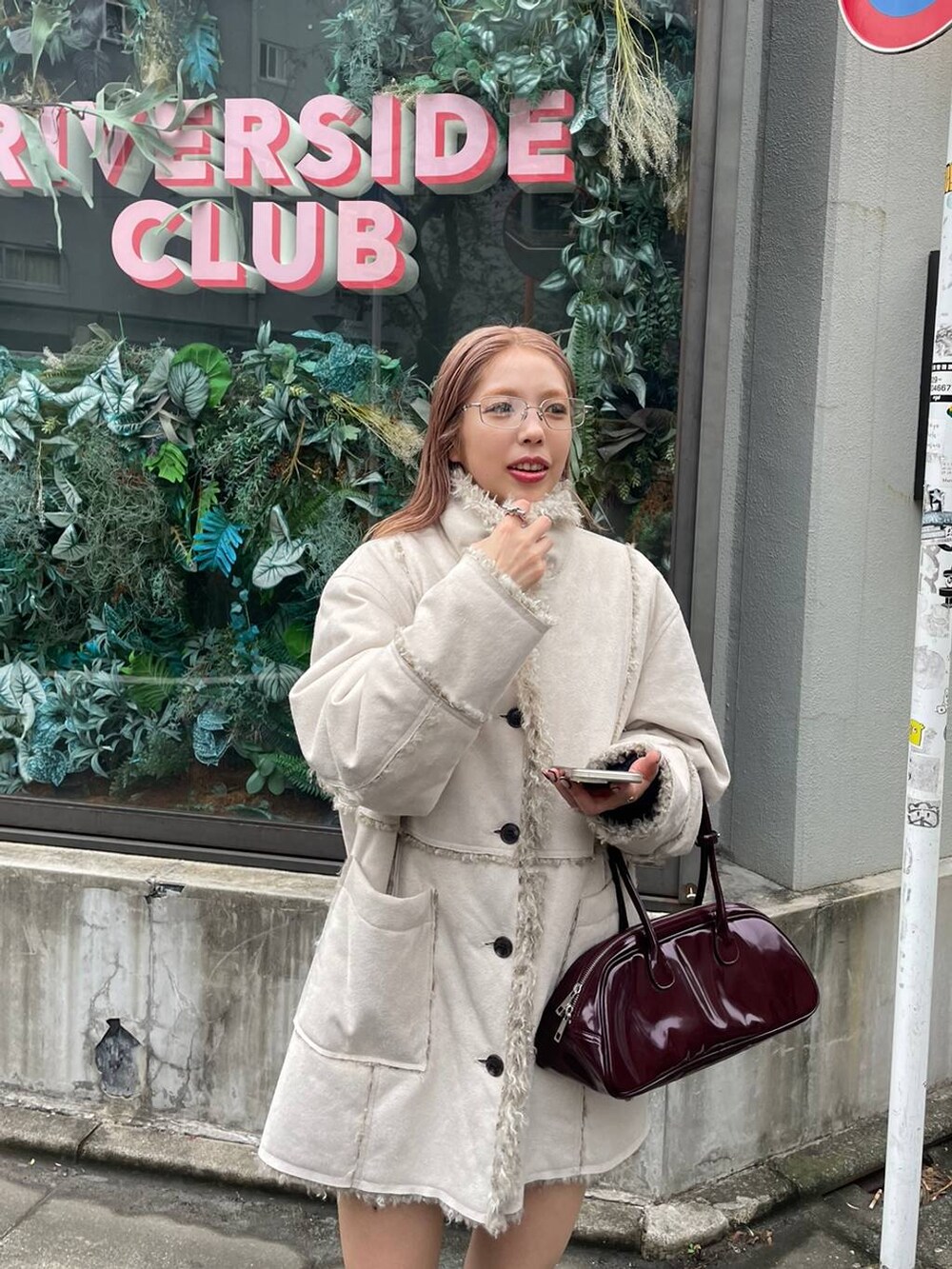 ブラック系のブーツ、レッド系のボストンバッグ、ホワイト系のブルゾンを着用したレディースの冬コーディネートの3枚目の写真