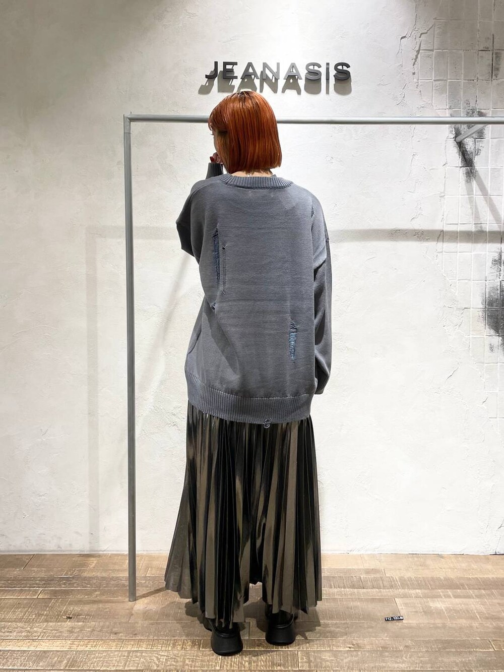 ブラック系のブーツ、シルバー系のスカート、グレー系のニット/セーターを着用したレディースの秋コーディネートの3枚目の写真