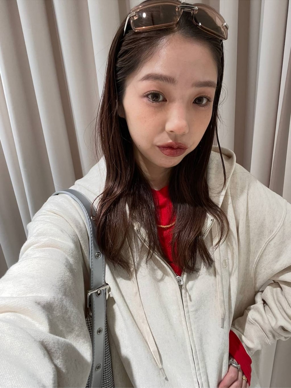 ブラック系のブーツ、ベージュ系のパーカー、シルバー系のハンドバッグを着用したレディースの冬コーディネートの4枚目の写真