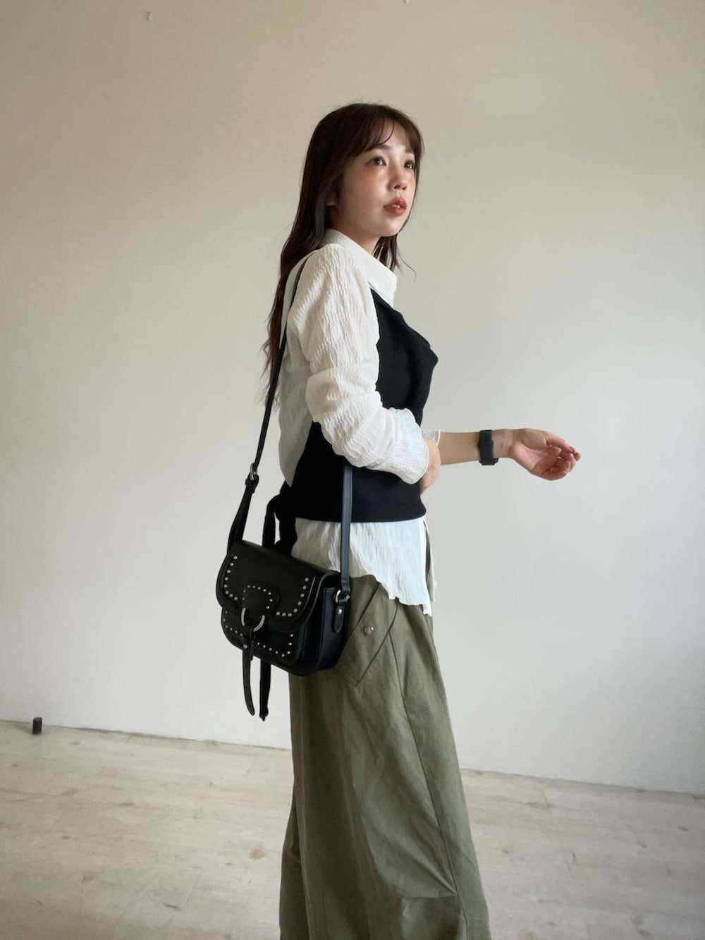 ブラック系のパンプス、ブラック系のショルダーバッグ、ホワイト系のシャツ/ブラウスを着用したレディースの秋コーディネートの4枚目の写真