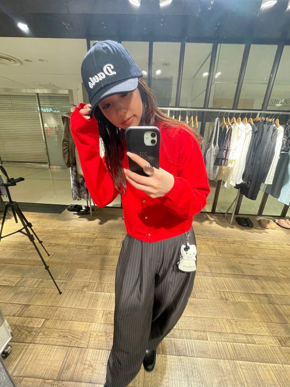 ブラウン系のローファー、レッド系のカーディガン/ボレロ、ブルー系のキャップを着用したレディースの春コーディネートの3枚目の写真