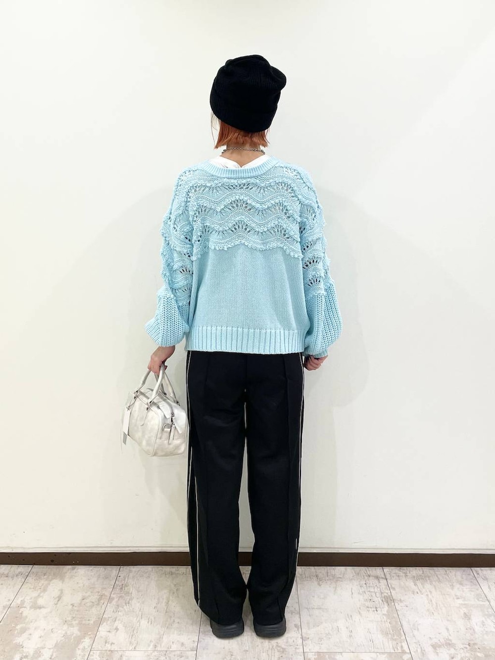 ブラック系のブーツ、ホワイト系のボストンバッグ、ブルー系のニット/セーターを着用したレディースの秋コーディネートの3枚目の写真