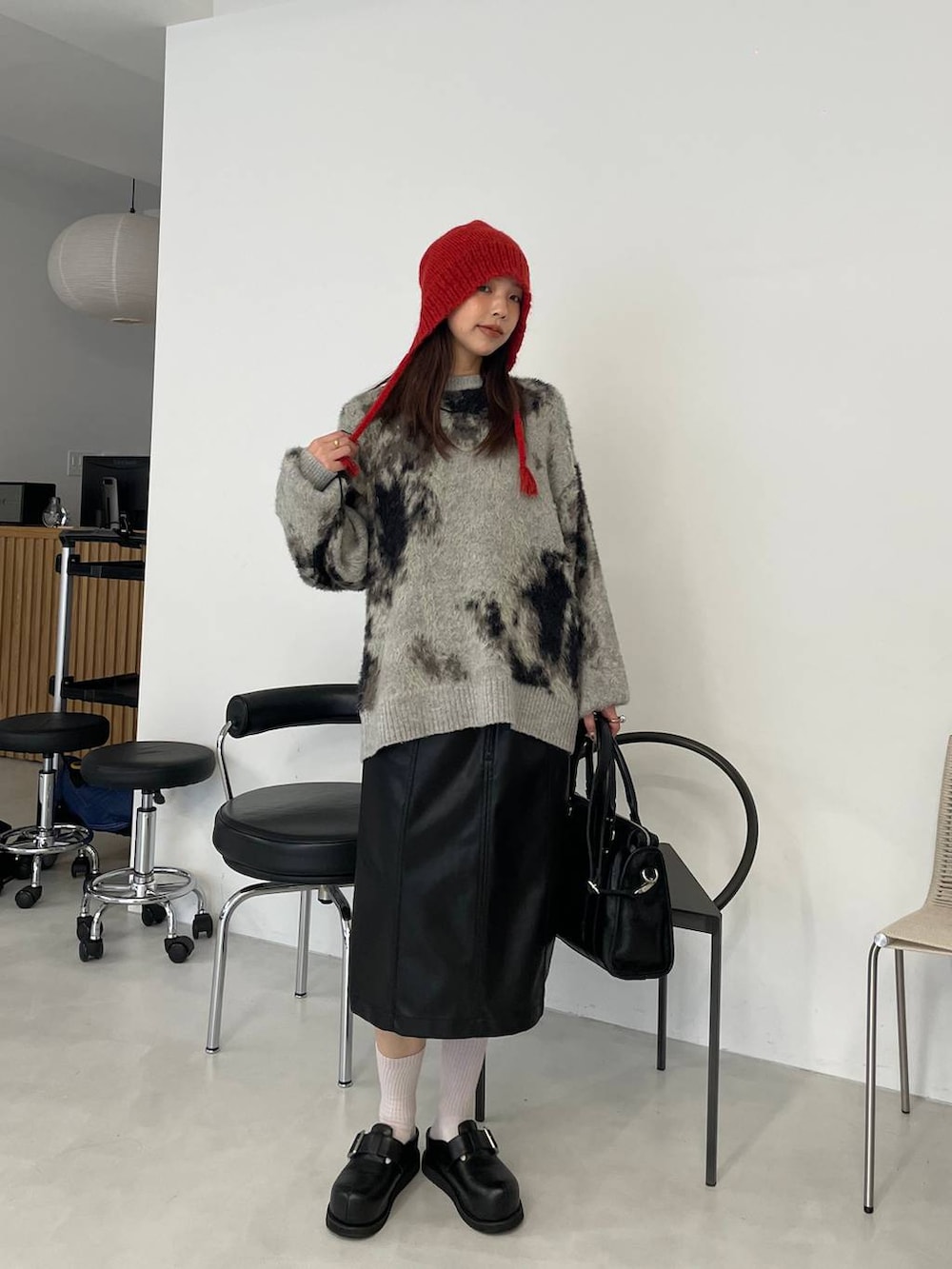 グレー系のニット/セーター、ブラック系のボストンバッグ、ブラック系のその他シューズを着用したレディースの秋コーディネートの3枚目の写真