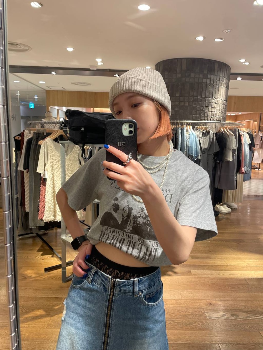 ブルー系のスカート、ブラック系のショルダーバッグ、グレー系のTシャツ/カットソーを着用したレディースの夏コーディネートの3枚目の写真