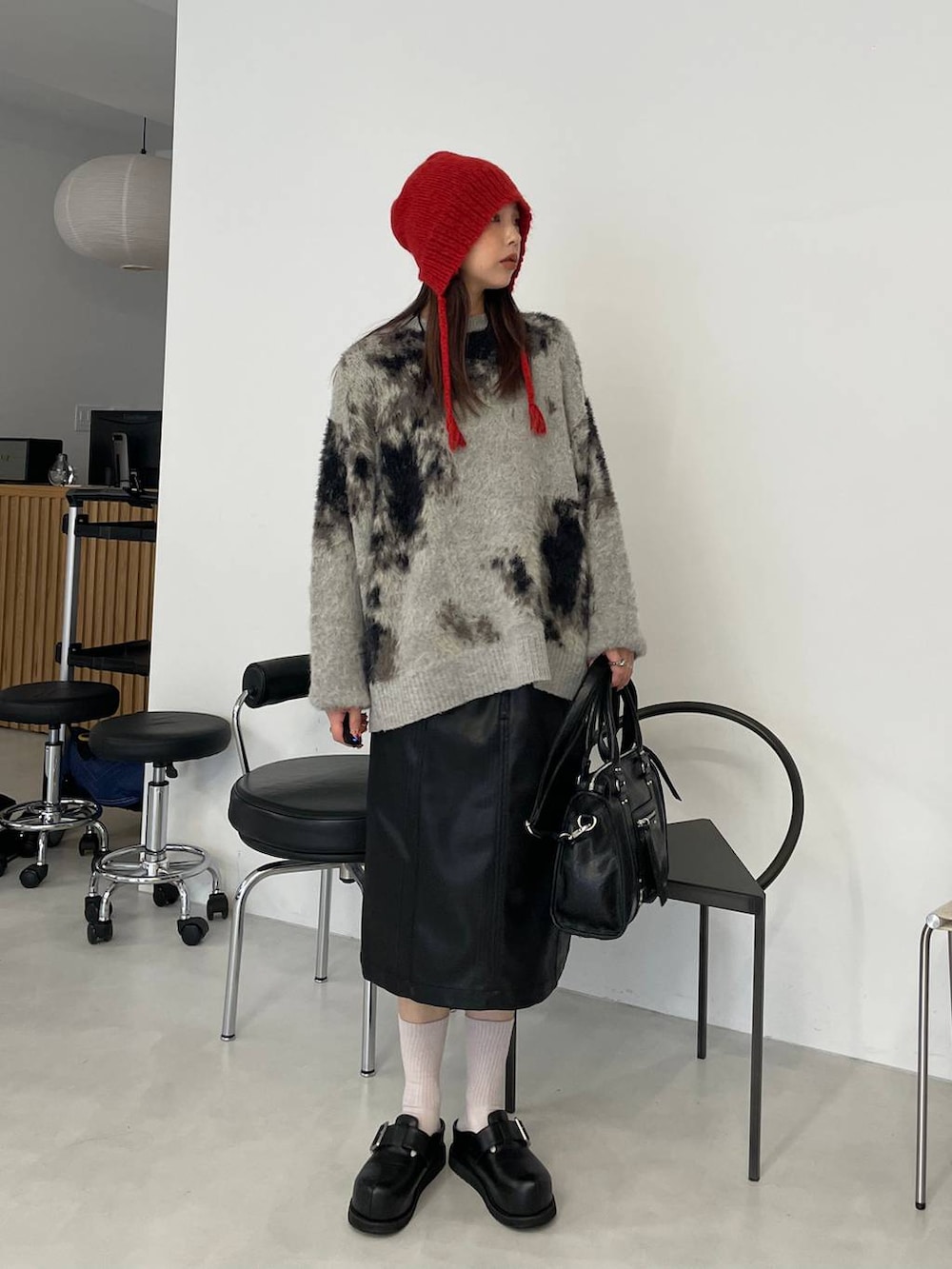 グレー系のニット/セーター、ブラック系のボストンバッグ、ブラック系のその他シューズを着用したレディースの秋コーディネートの2枚目の写真