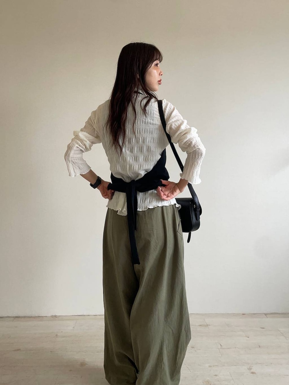 ブラック系のパンプス、ブラック系のショルダーバッグ、ホワイト系のシャツ/ブラウスを着用したレディースの秋コーディネートの3枚目の写真