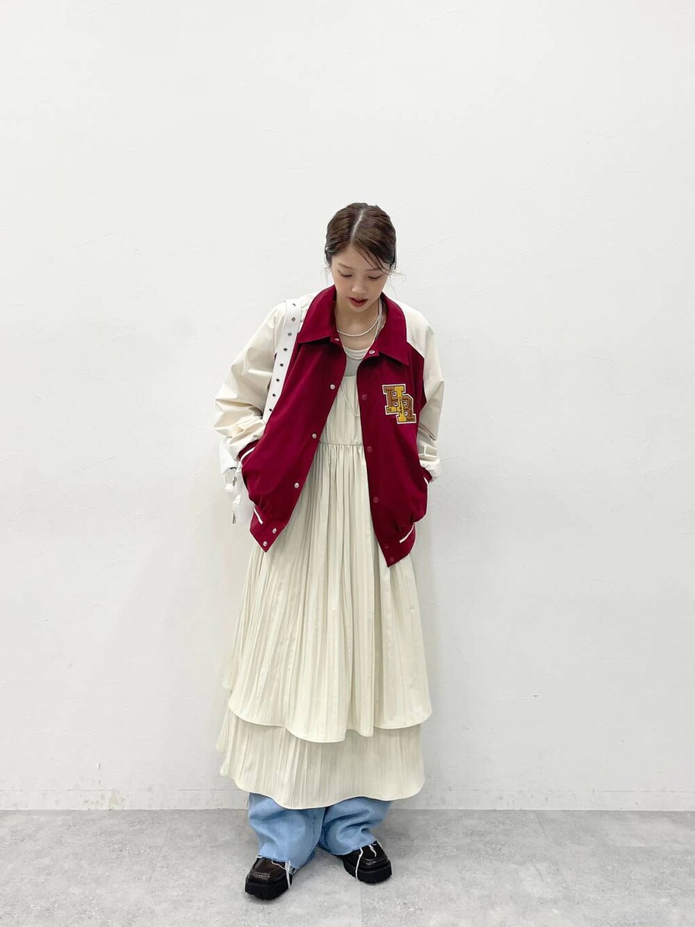 ホワイト系のショルダーバッグ、ブラウン系のローファー、ホワイト系のワンピースを着用したレディースの冬コーディネートの3枚目の写真