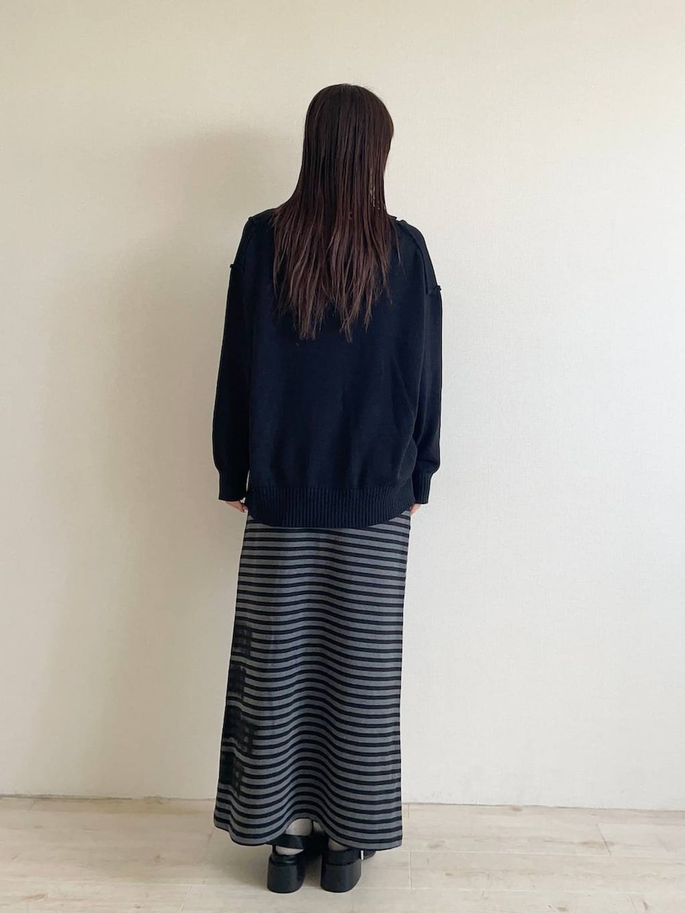 ブラック系のスカート、ブラック系のモカシン/デッキシューズ、ブラック系のカーディガン/ボレロを着用したレディースの秋コーディネートの2枚目の写真