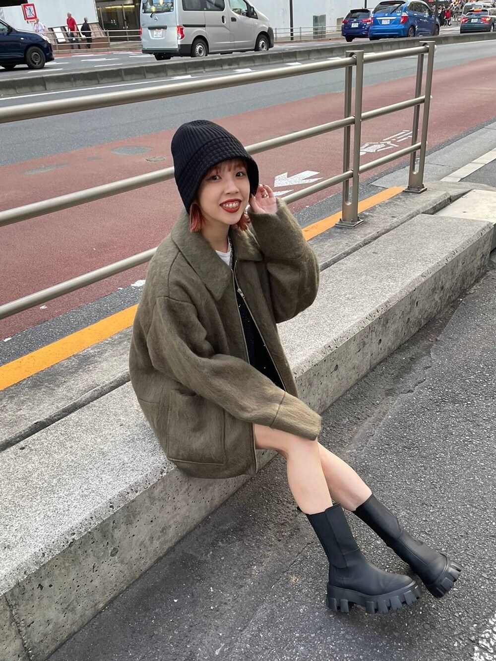 ブラック系のブーツ、グリーン系のステンカラーコート、ブラック系のカーディガン/ボレロを着用したレディースの秋コーディネートの3枚目の写真