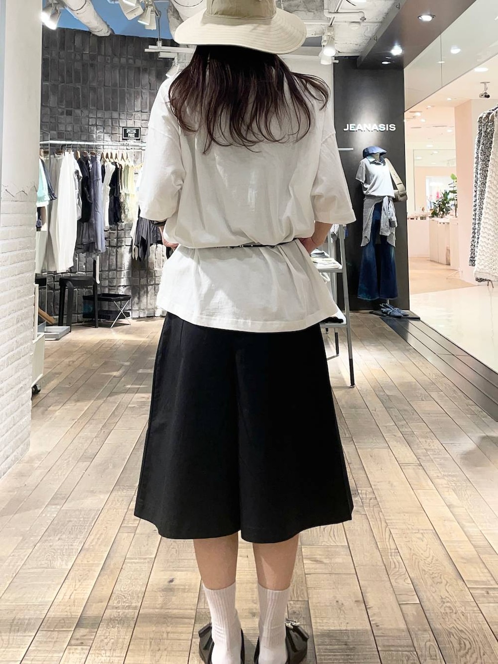 ブラック系のその他パンツ、ブラック系のサンダル、ホワイト系のTシャツ/カットソーを着用したレディースの春コーディネートの2枚目の写真