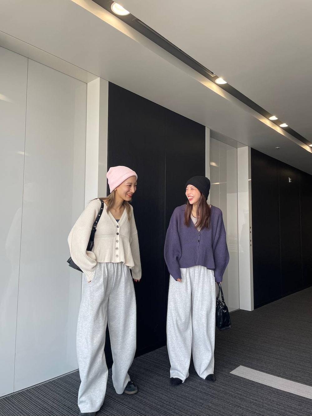 ベージュ系のタンクトップ、ブラック系のショルダーバッグ、グレー系のスウェットパンツを着用したレディースの秋コーディネートの2枚目の写真