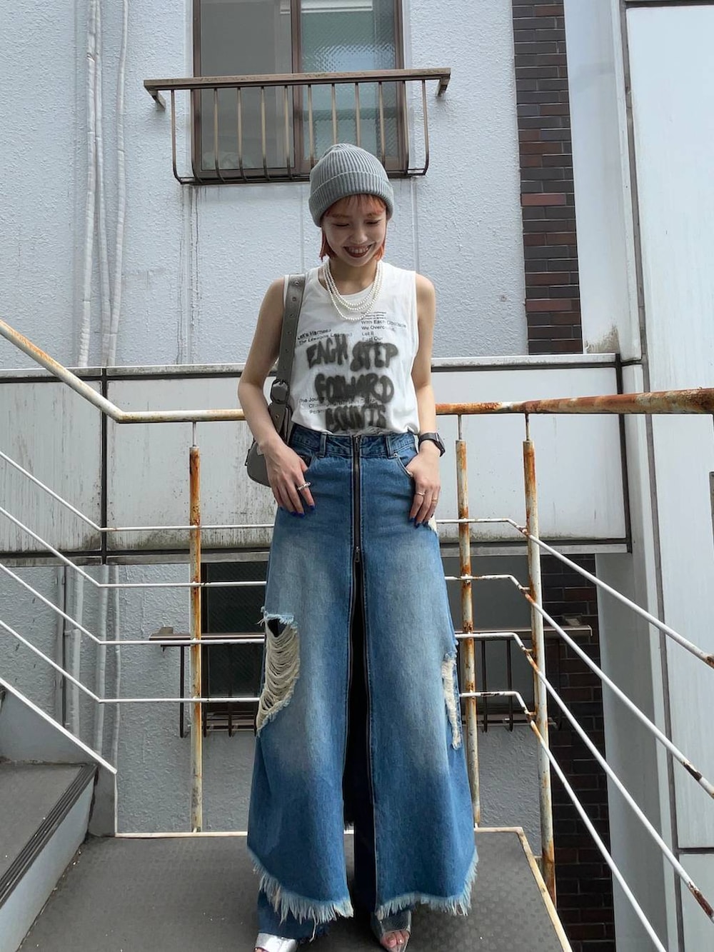 シルバー系のサンダル、ブルー系のスカート、シルバー系のショルダーバッグを着用したレディースの夏コーディネートの6枚目の写真