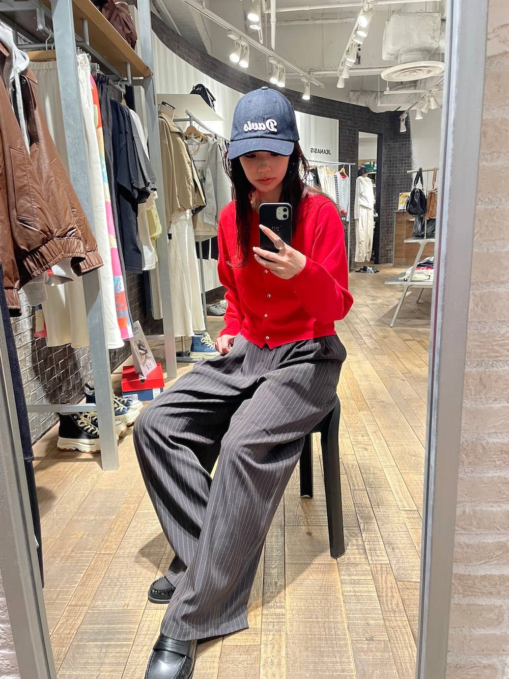 ブラウン系のローファー、レッド系のカーディガン/ボレロ、ブルー系のキャップを着用したレディースの春コーディネートの2枚目の写真