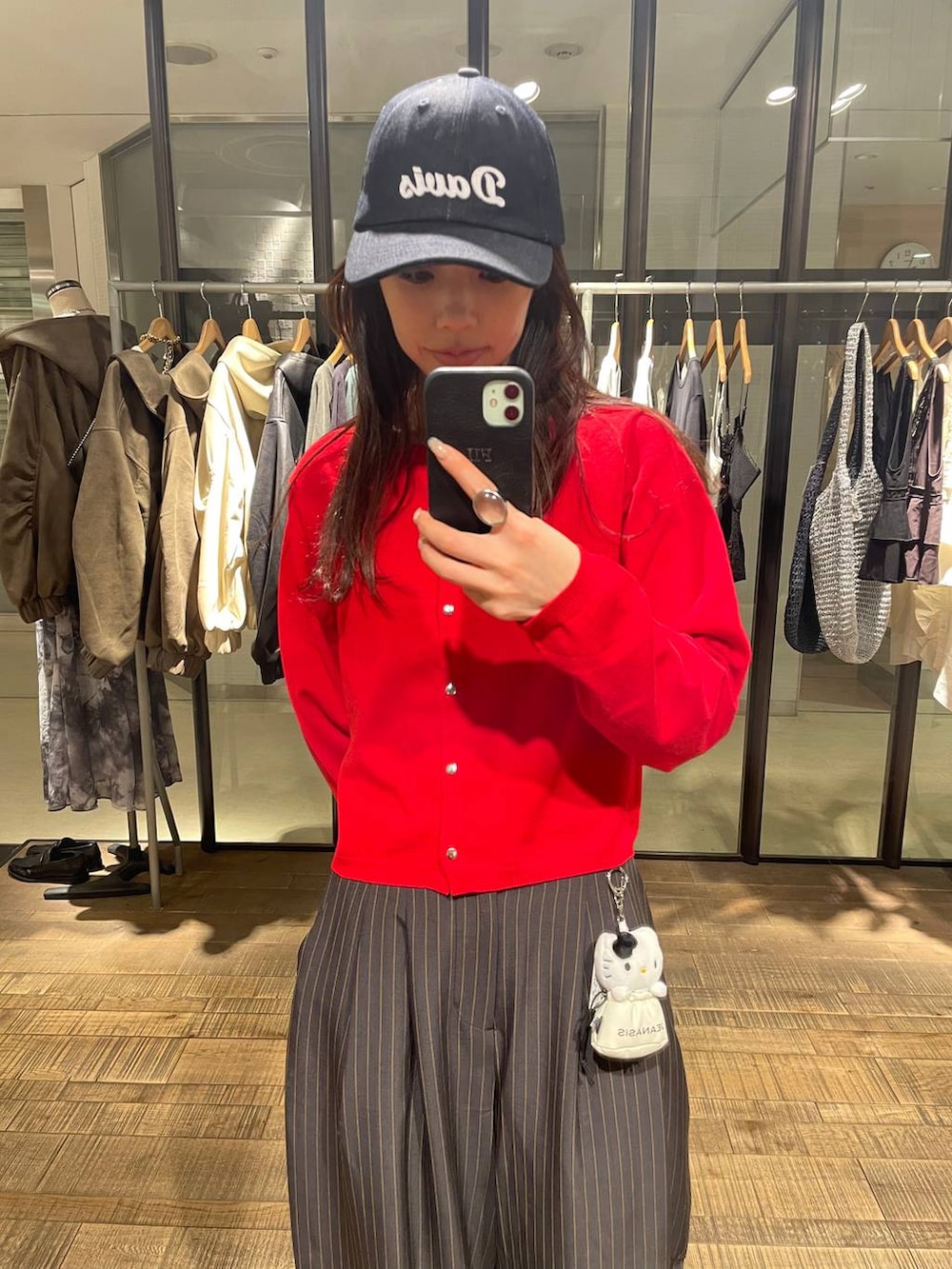 ブラウン系のローファー、レッド系のカーディガン/ボレロ、ブルー系のキャップを着用したレディースの春コーディネートの4枚目の写真