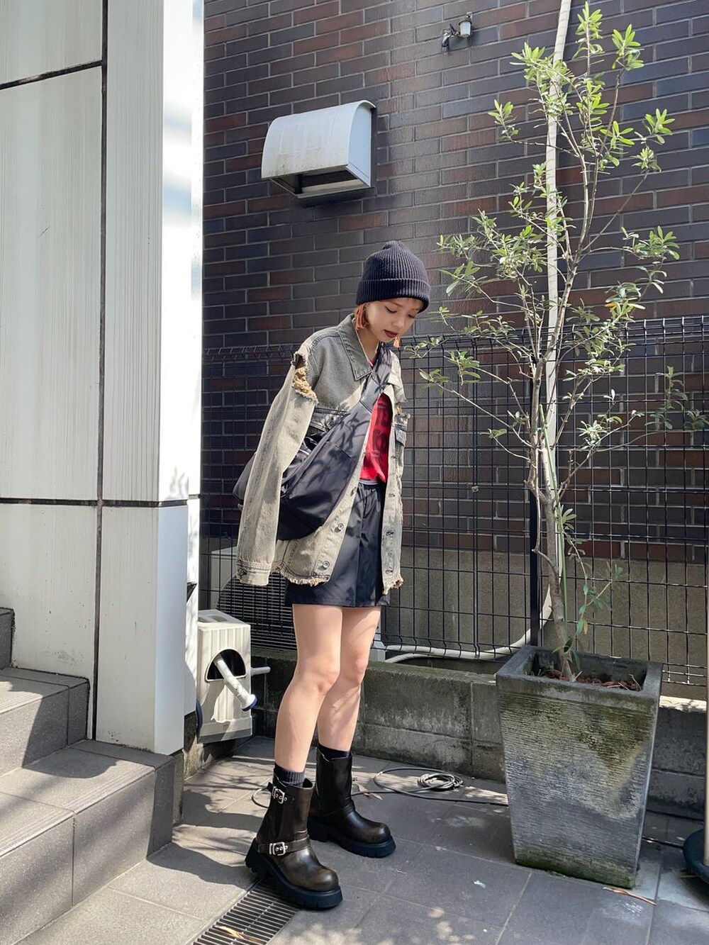 ブラック系のその他パンツ、ブラック系のショルダーバッグ、レッド系のTシャツ/カットソーを着用したレディースの夏コーディネートの3枚目の写真